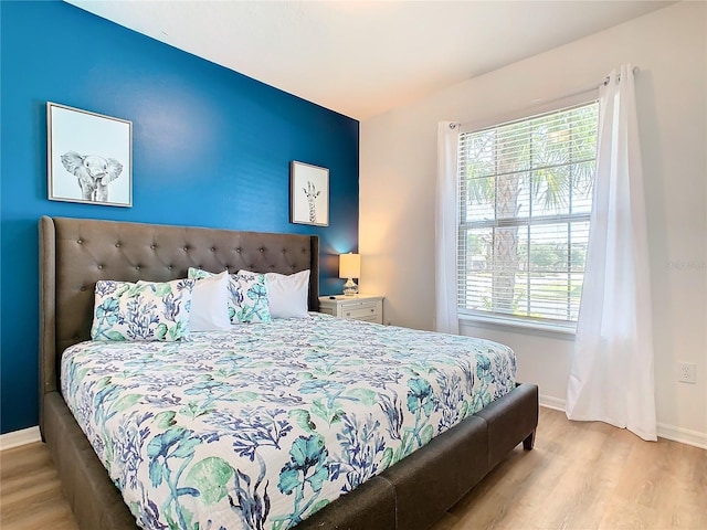 bedroom with multiple windows and light hardwood / wood-style flooring