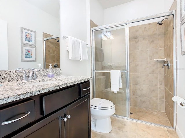 bathroom featuring a shower with door, vanity, tile patterned floors, and toilet