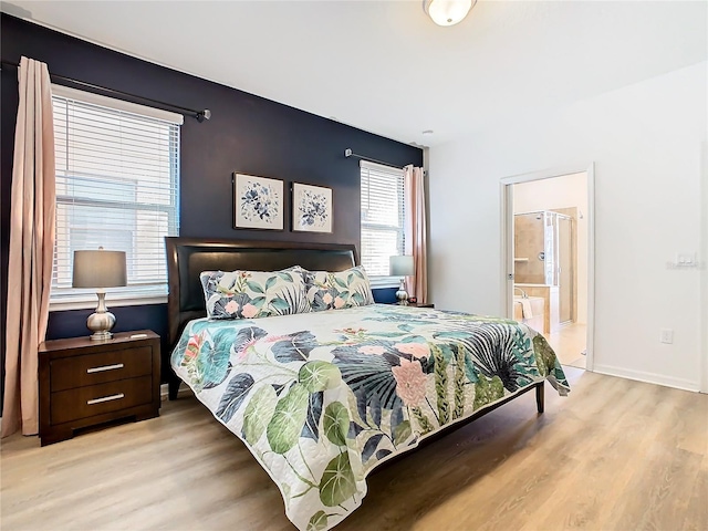 bedroom with light wood-type flooring and ensuite bathroom