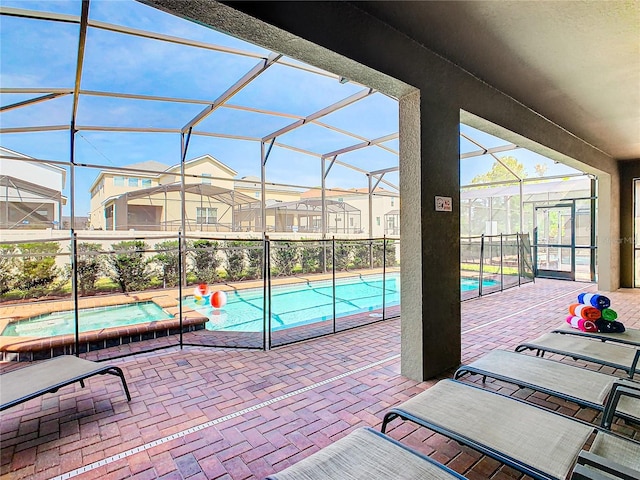 view of patio featuring a swimming pool with hot tub and a lanai