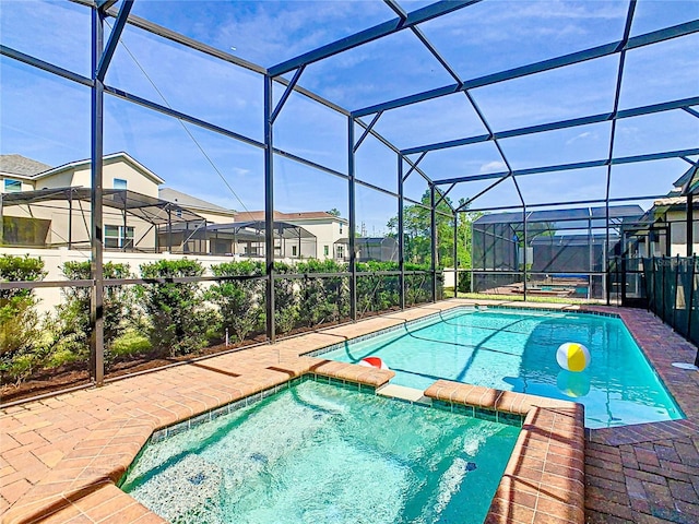 view of pool with an in ground hot tub and glass enclosure