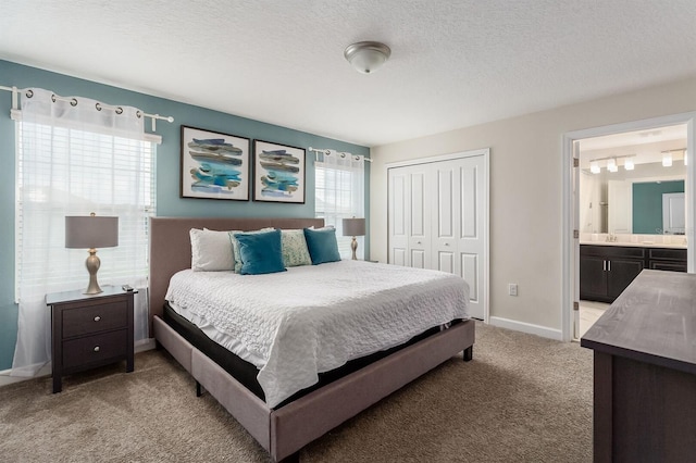 bedroom with a closet, light carpet, multiple windows, and a textured ceiling