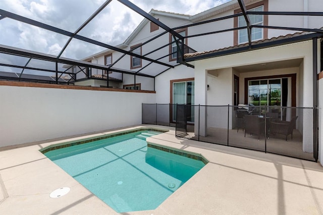 view of pool with a patio area and glass enclosure