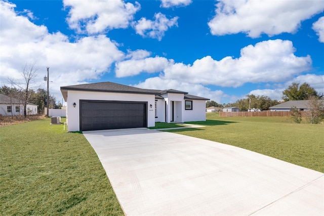 view of front facade with a garage, a front lawn, and central air condition unit