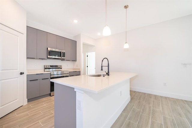 kitchen with gray cabinets, appliances with stainless steel finishes, sink, and pendant lighting