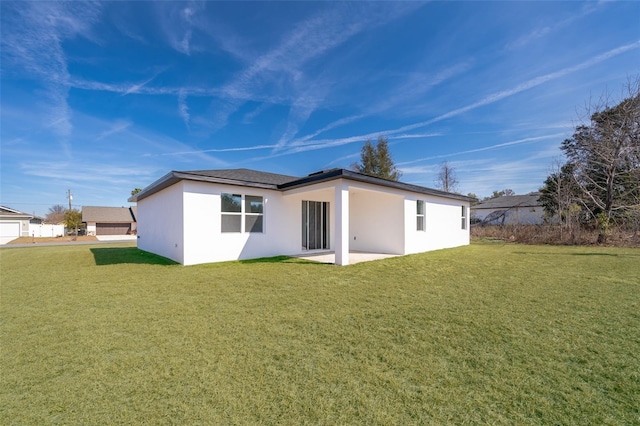 rear view of property featuring a yard and a patio area