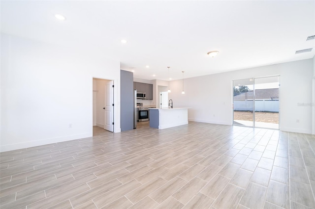 unfurnished living room with sink