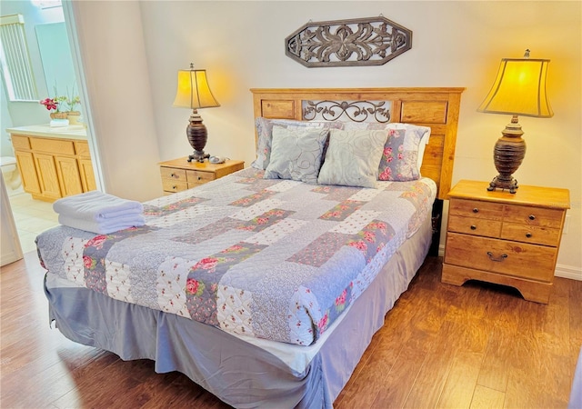 bedroom featuring hardwood / wood-style floors and ensuite bath