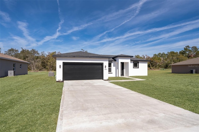 view of front of property with a garage, a front yard, and central air condition unit