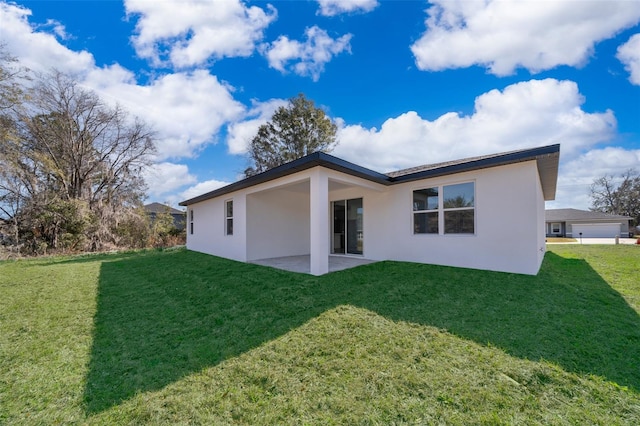 rear view of property featuring a yard and a patio