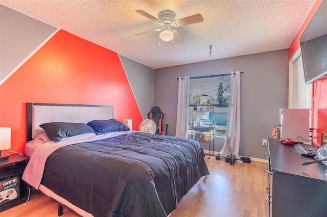 bedroom featuring a textured ceiling, ceiling fan, and light hardwood / wood-style flooring