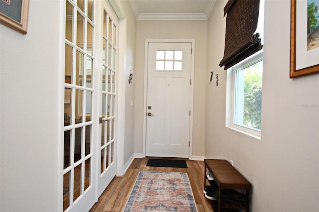 doorway to outside with ornamental molding and wood-type flooring