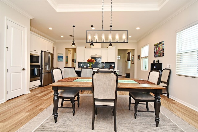 dining space with crown molding and light hardwood / wood-style flooring