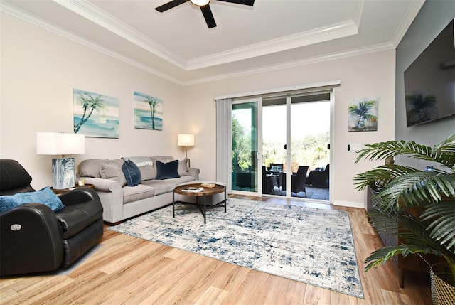 living room featuring ornamental molding, hardwood / wood-style floors, ceiling fan, and a tray ceiling