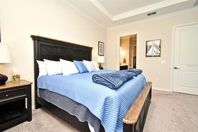 carpeted bedroom with crown molding, ensuite bathroom, and a raised ceiling