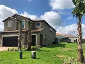 view of front of property with a garage and a front lawn