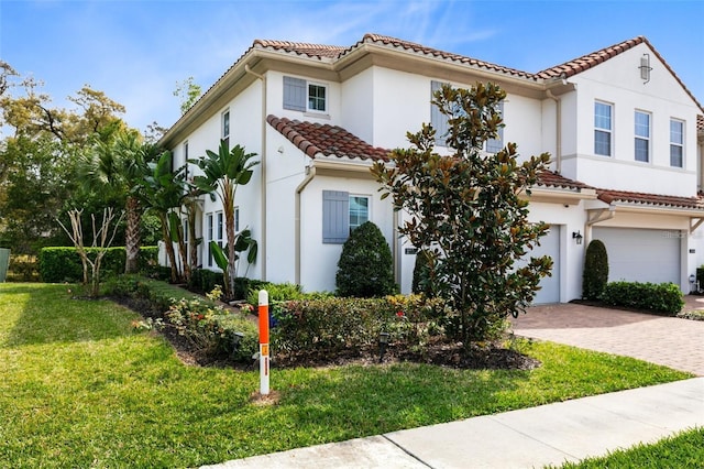 mediterranean / spanish house with a garage and a front lawn