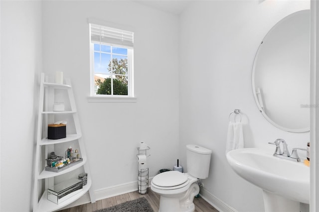 bathroom with hardwood / wood-style flooring, toilet, and sink