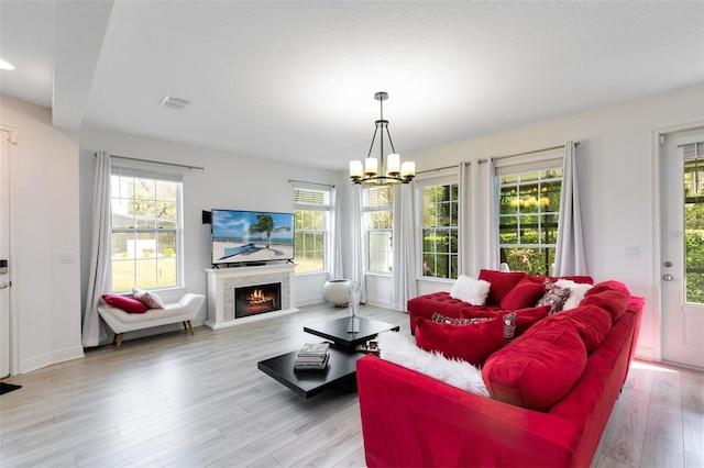 living room with a notable chandelier and light hardwood / wood-style floors