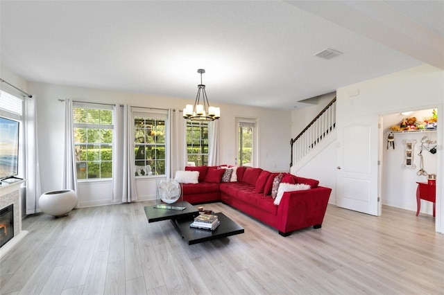 living room featuring an inviting chandelier and light wood-type flooring