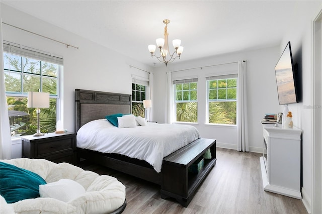 bedroom with hardwood / wood-style floors and a chandelier