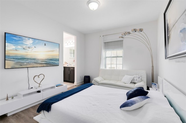 bedroom featuring hardwood / wood-style flooring and ensuite bathroom