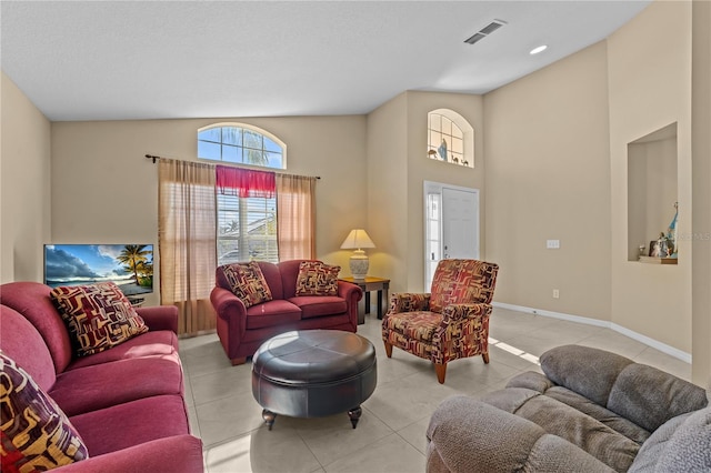 living room featuring a towering ceiling and light tile patterned floors