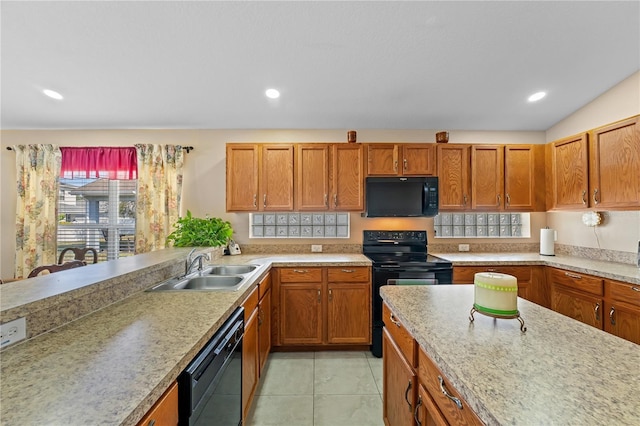 kitchen featuring sink, light tile patterned floors, and black appliances