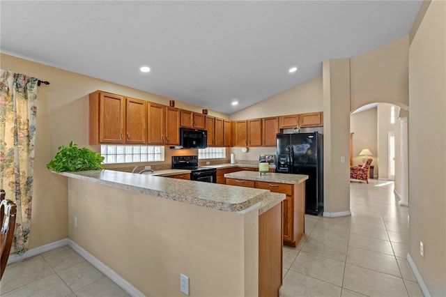 kitchen with lofted ceiling, kitchen peninsula, light tile patterned floors, and black appliances