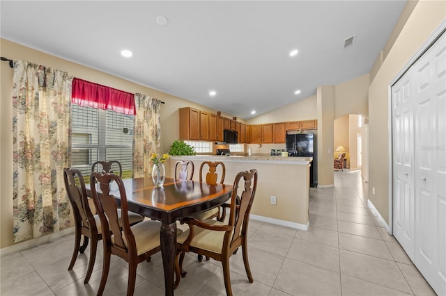 tiled dining space with vaulted ceiling