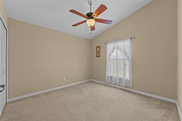 spare room featuring lofted ceiling, light colored carpet, and ceiling fan