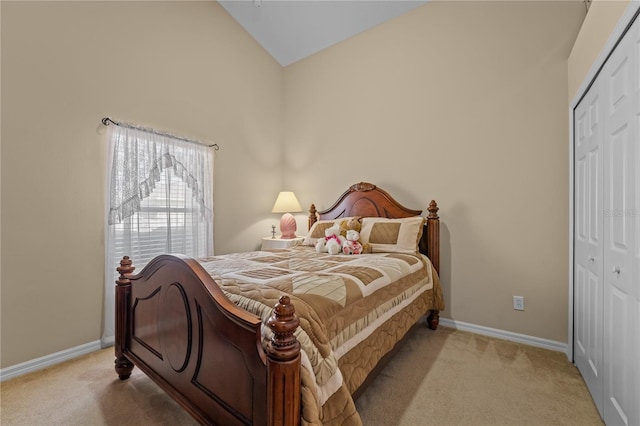 bedroom with a closet, lofted ceiling, and light carpet