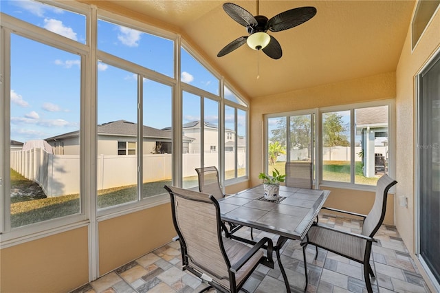 sunroom / solarium featuring lofted ceiling and ceiling fan