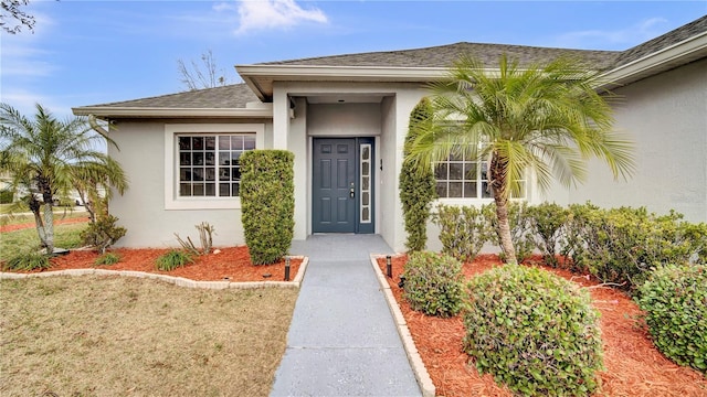 view of exterior entry featuring a yard