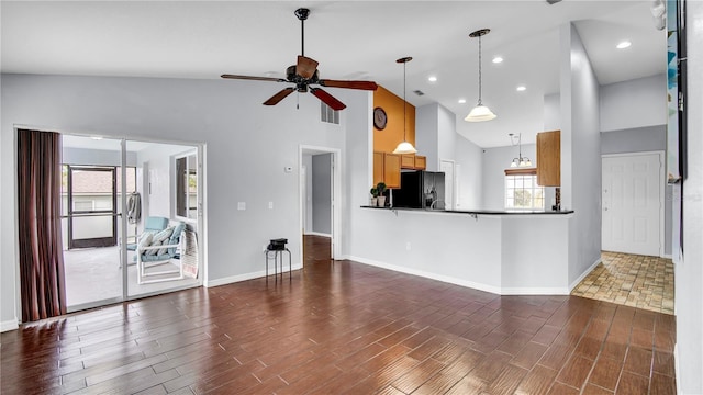 kitchen featuring ceiling fan, high vaulted ceiling, black refrigerator with ice dispenser, and hanging light fixtures