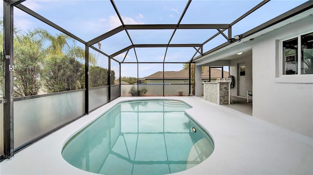 view of pool with a patio and glass enclosure