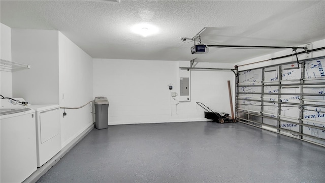 garage with a garage door opener, electric panel, and washer and dryer