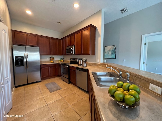 kitchen featuring sink, light tile patterned flooring, and appliances with stainless steel finishes