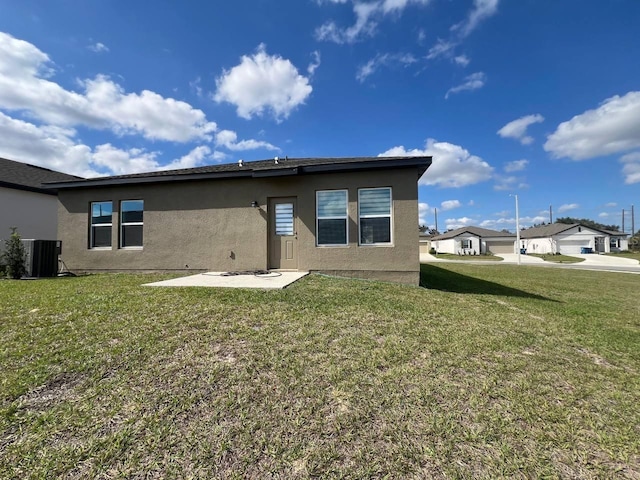 back of property featuring a patio, a lawn, central AC unit, and stucco siding