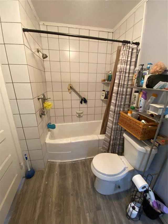 bathroom featuring crown molding, hardwood / wood-style flooring, shower / bath combo with shower curtain, and toilet