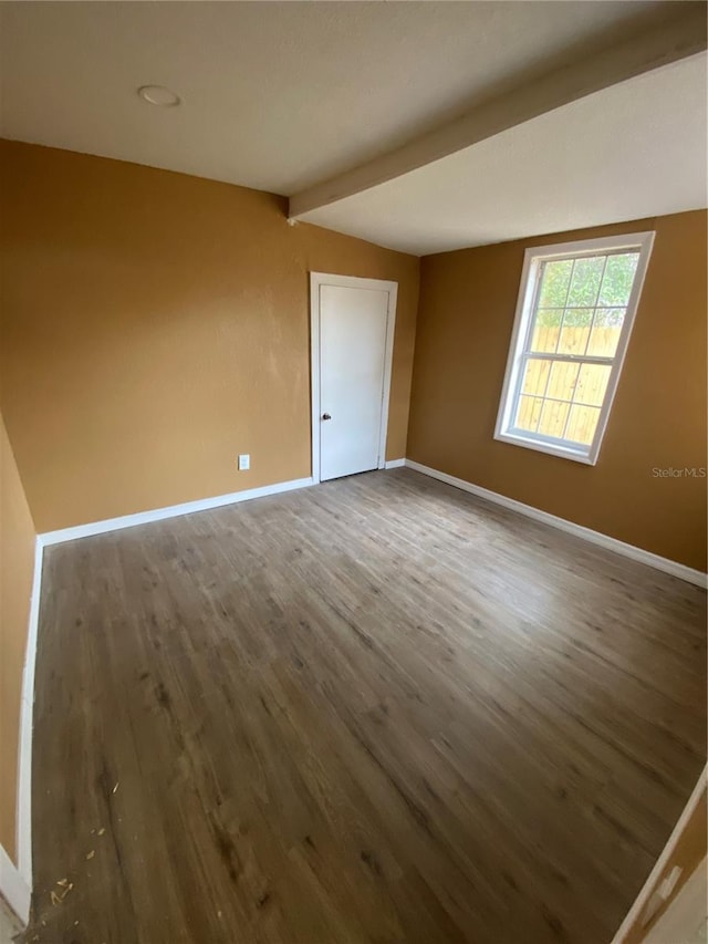 unfurnished room with vaulted ceiling with beams and dark hardwood / wood-style flooring