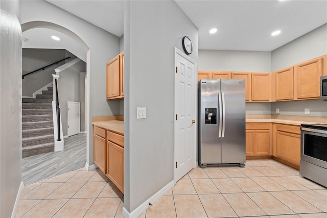 kitchen featuring light tile patterned flooring, appliances with stainless steel finishes, and light brown cabinetry