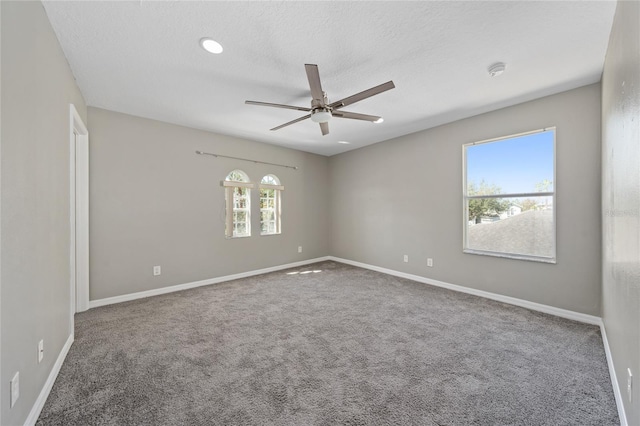 empty room featuring ceiling fan, carpet, and a textured ceiling