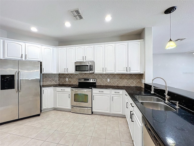 kitchen with stainless steel appliances, sink, white cabinets, and decorative light fixtures