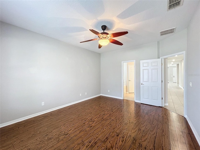 spare room with dark hardwood / wood-style floors, a textured ceiling, and ceiling fan