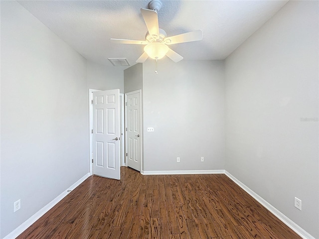 empty room with dark wood-type flooring and ceiling fan