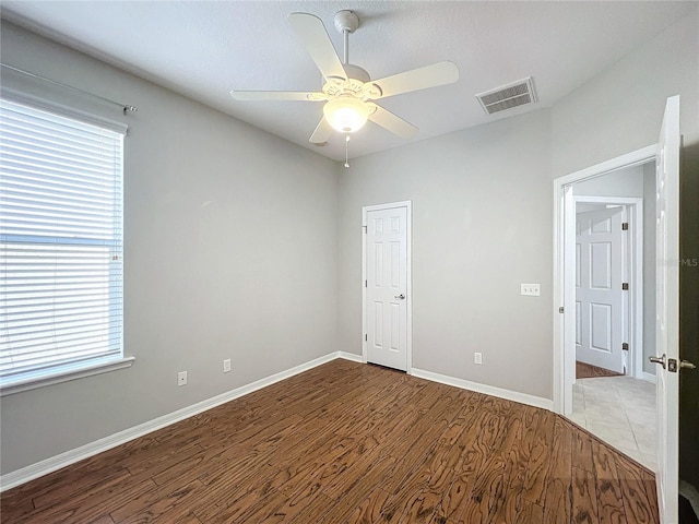 unfurnished room with hardwood / wood-style floors and ceiling fan