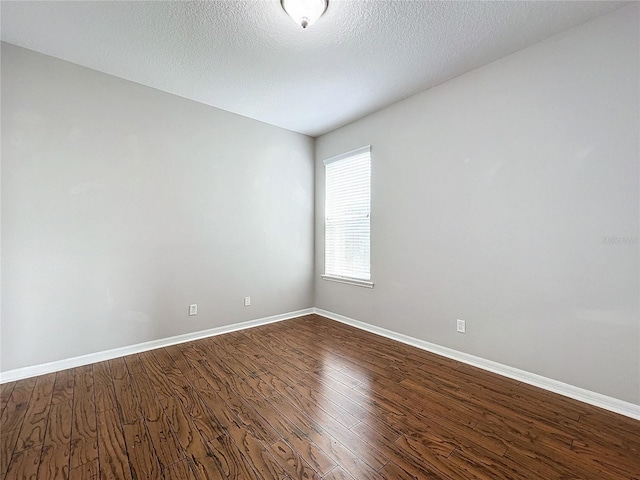 unfurnished room with hardwood / wood-style flooring and a textured ceiling