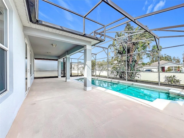 view of swimming pool featuring a patio and glass enclosure