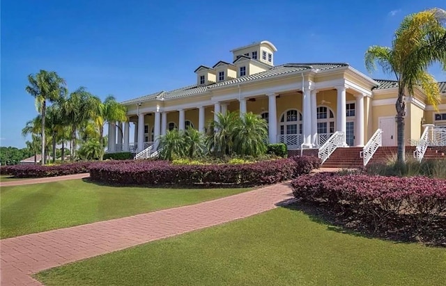 neoclassical home featuring a porch and a front lawn